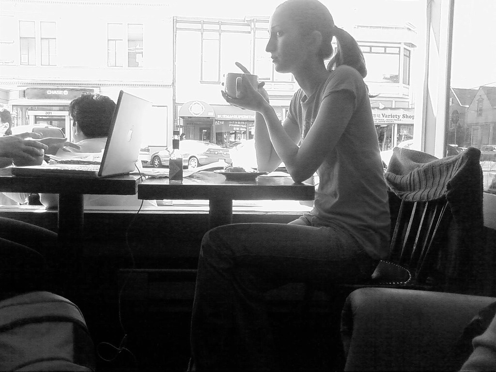 Persona reflexionando con un café junto a la ventana