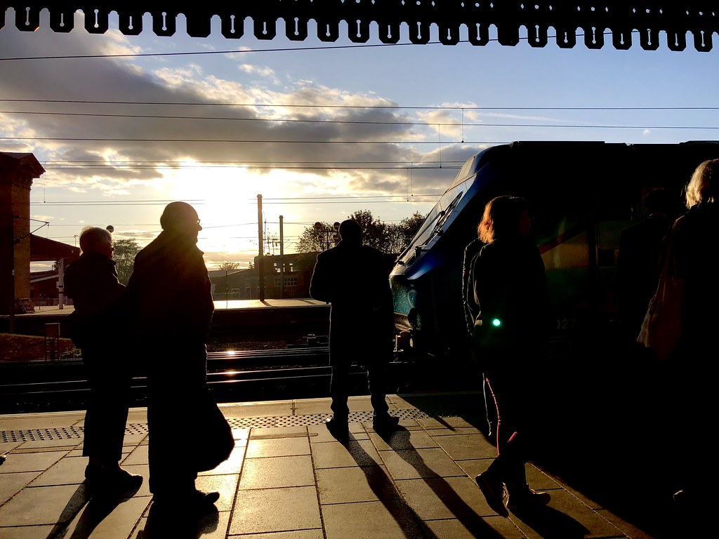 Viajeros en un andén al atardecer al inicio de las vacaciones