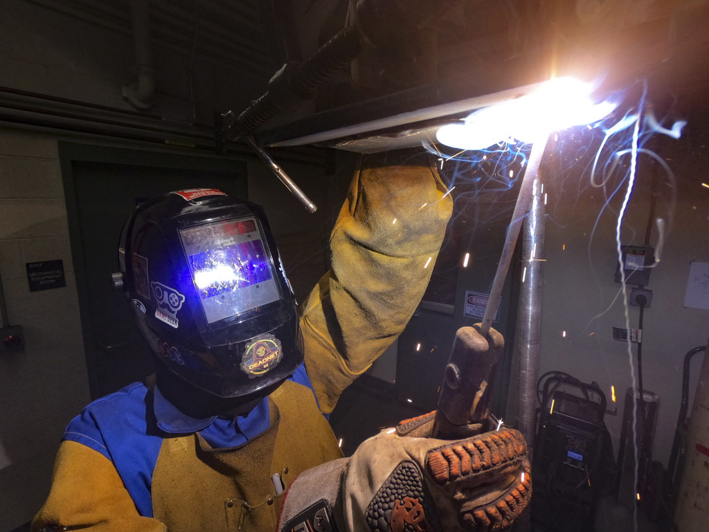 Soldador trabajando más allá de su turno en una nave industrial