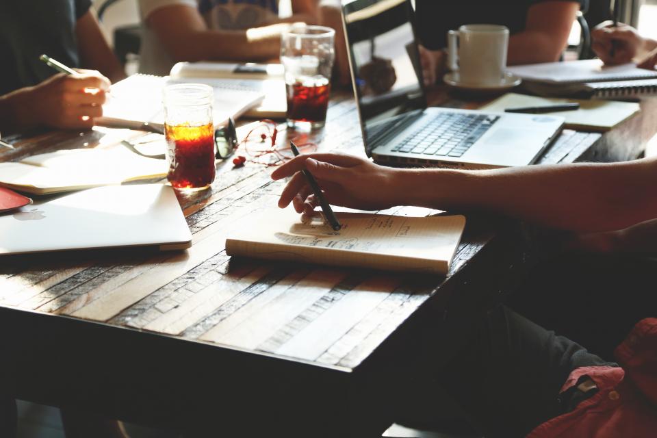 Personas trabajando alrededor de una mesa de reuniones