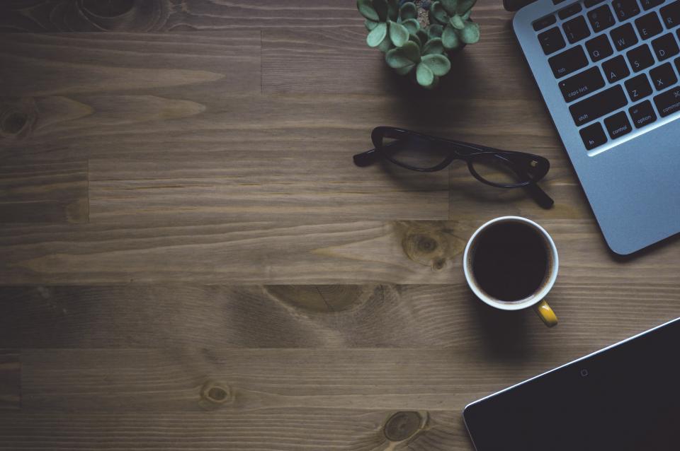 Mesa con café y portátil simbolizando una pausa profesional