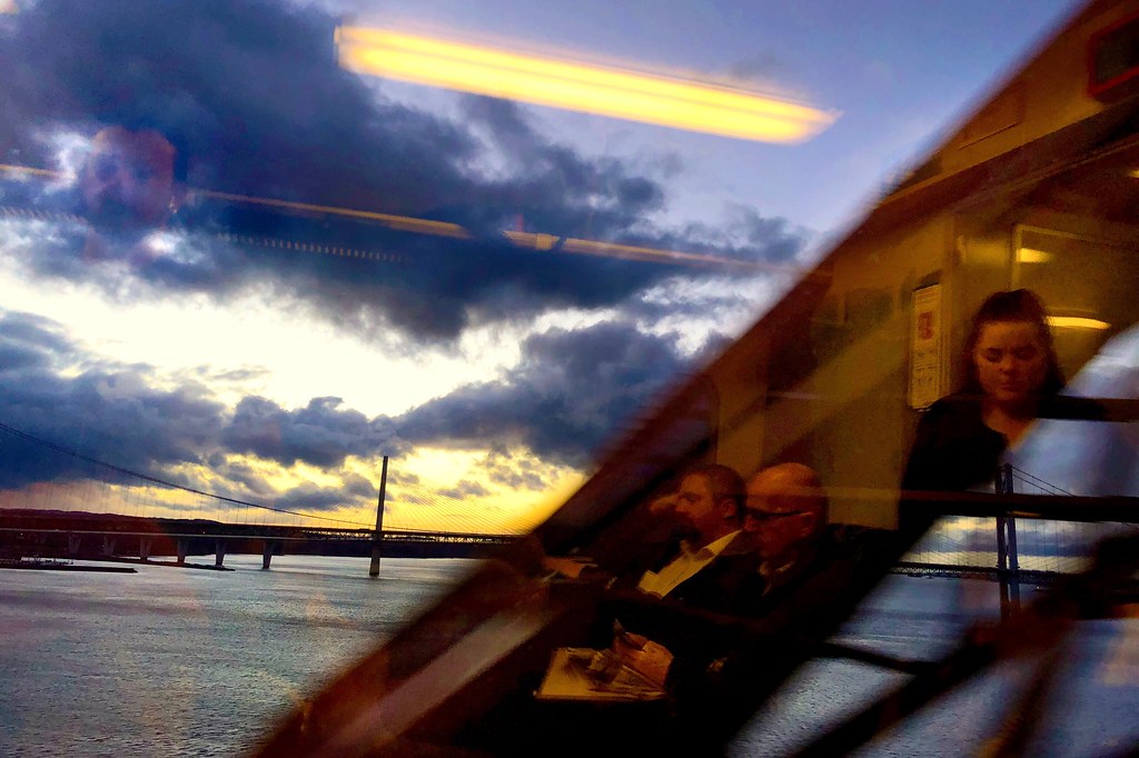 Vista desde un tren cruzando un puente al atardecer