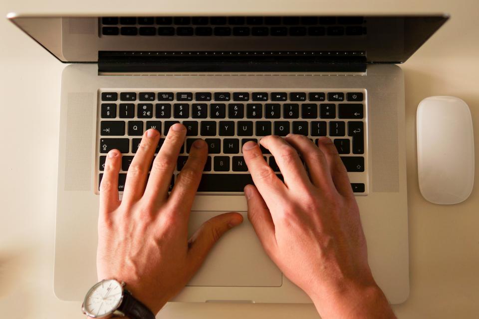 Manos escribiendo un correo de agradecimiento en el portátil