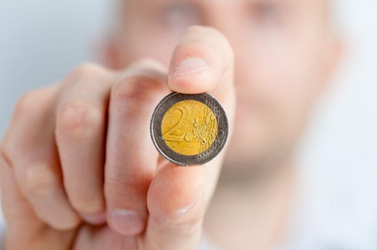 Mano mostrando una moneda de dos euros