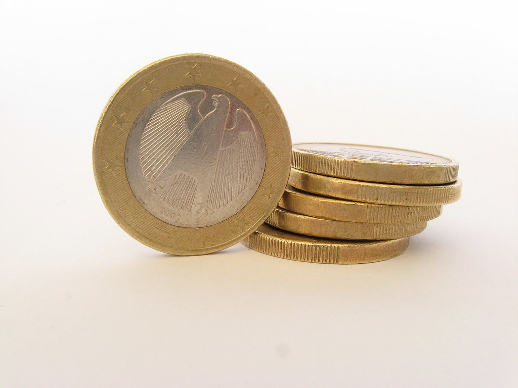 Monedas de euro apiladas junto a un documento